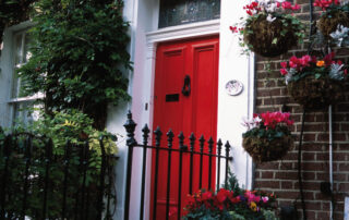 House with Red Front Door Hanging Baskets